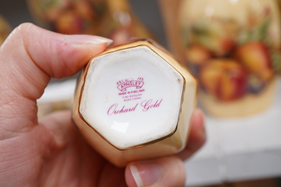 A collection of Aynsley Orchard Gold wares including a timepiece, vases, etc. tallest 23cm